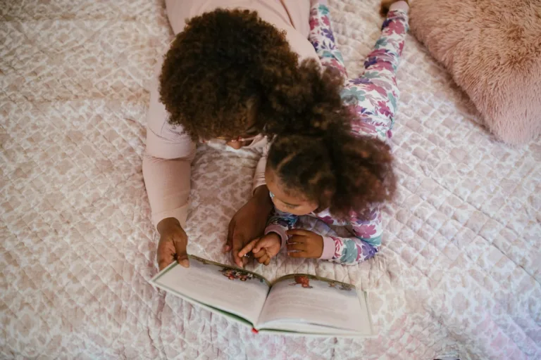 Teacher-Parent Collaboration in the Reggio Emilia Approach: Building a Strong Community for Children 9 A mother and daughter enjoying storytime on a cozy bed, fostering bonding and togetherness.